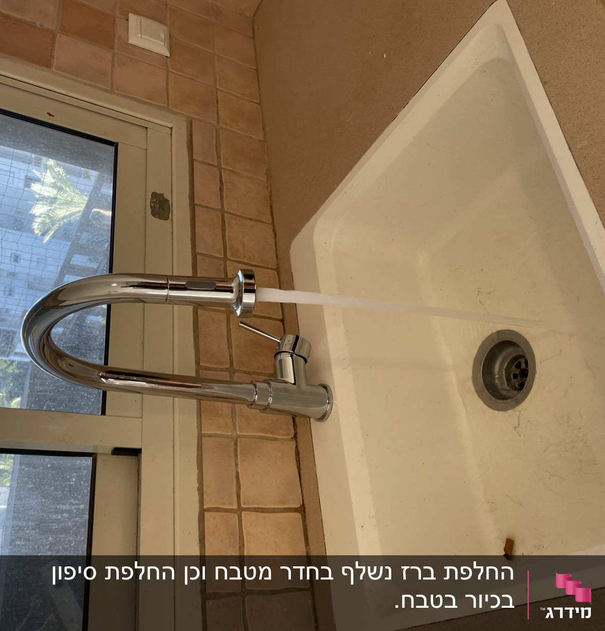 ברז מים זורם בכיור מטבח לבן